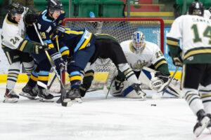 Eric Young with his eyes on the puck amongst the chaos in front of his net. (Chad Goddard/Okotoks Oilers)